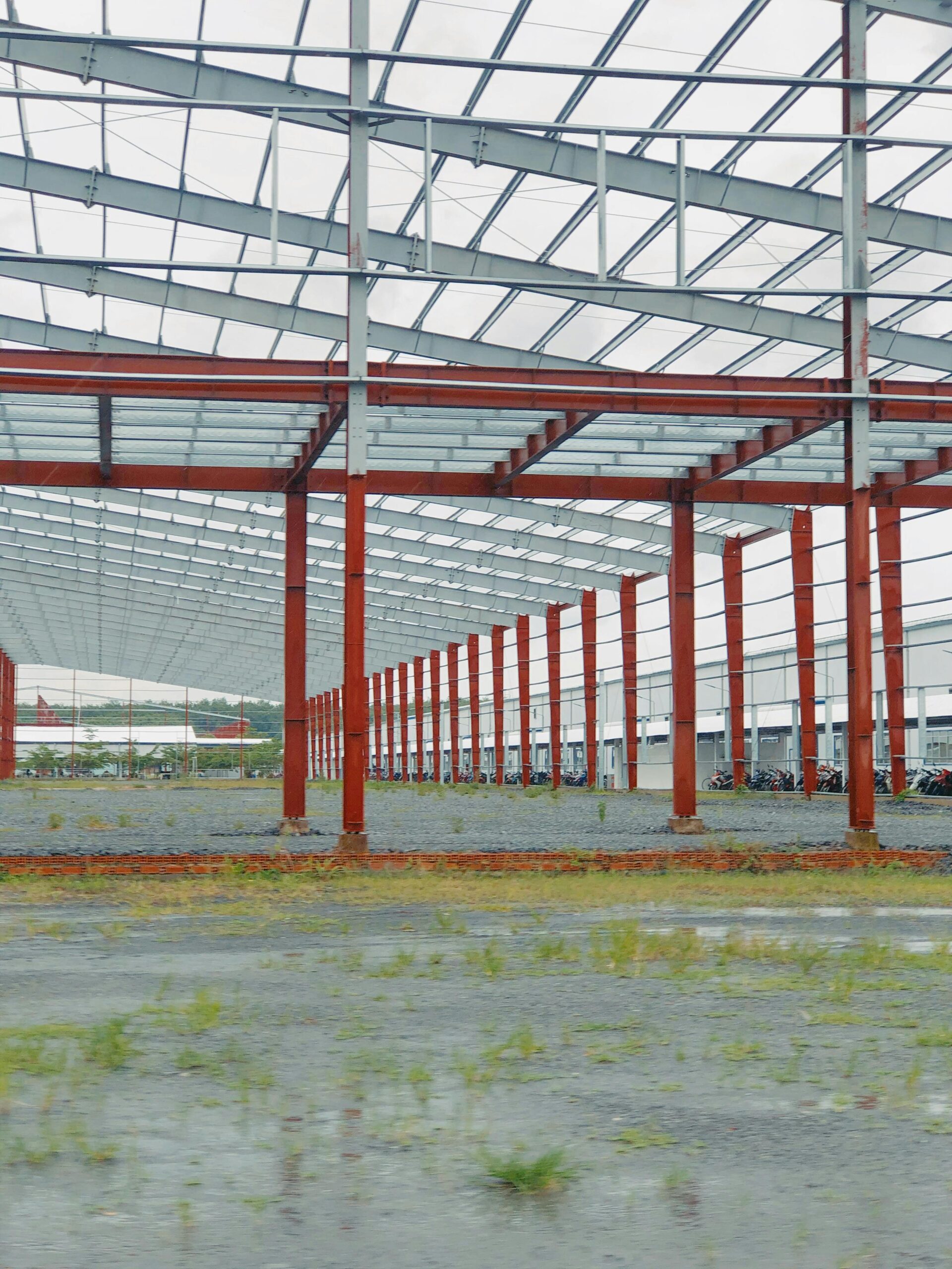An expansive metal frame structure under construction in an open, industrial space.